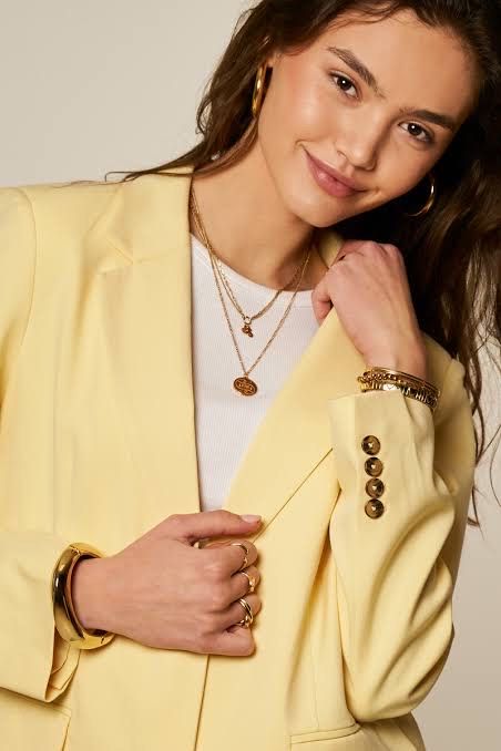 sculpted shoulder blazer and statement jewelry, 2026 statement silhouette trend.