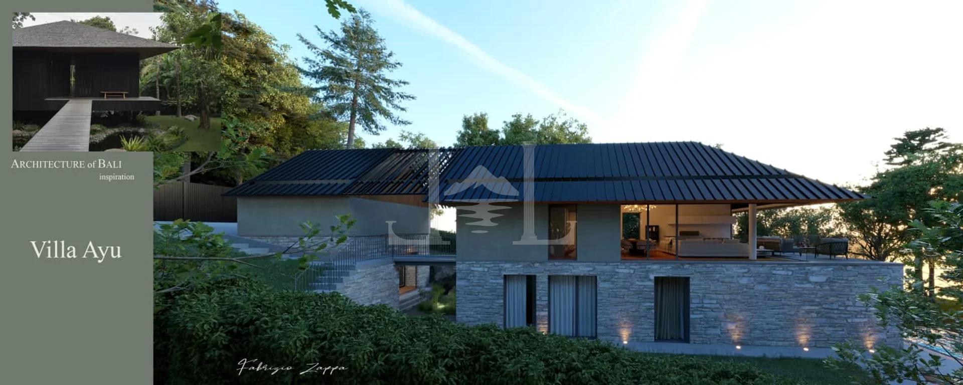 Exterior view of the modern villa, distinguished by elegant stone cladding and a dark pitched roof.