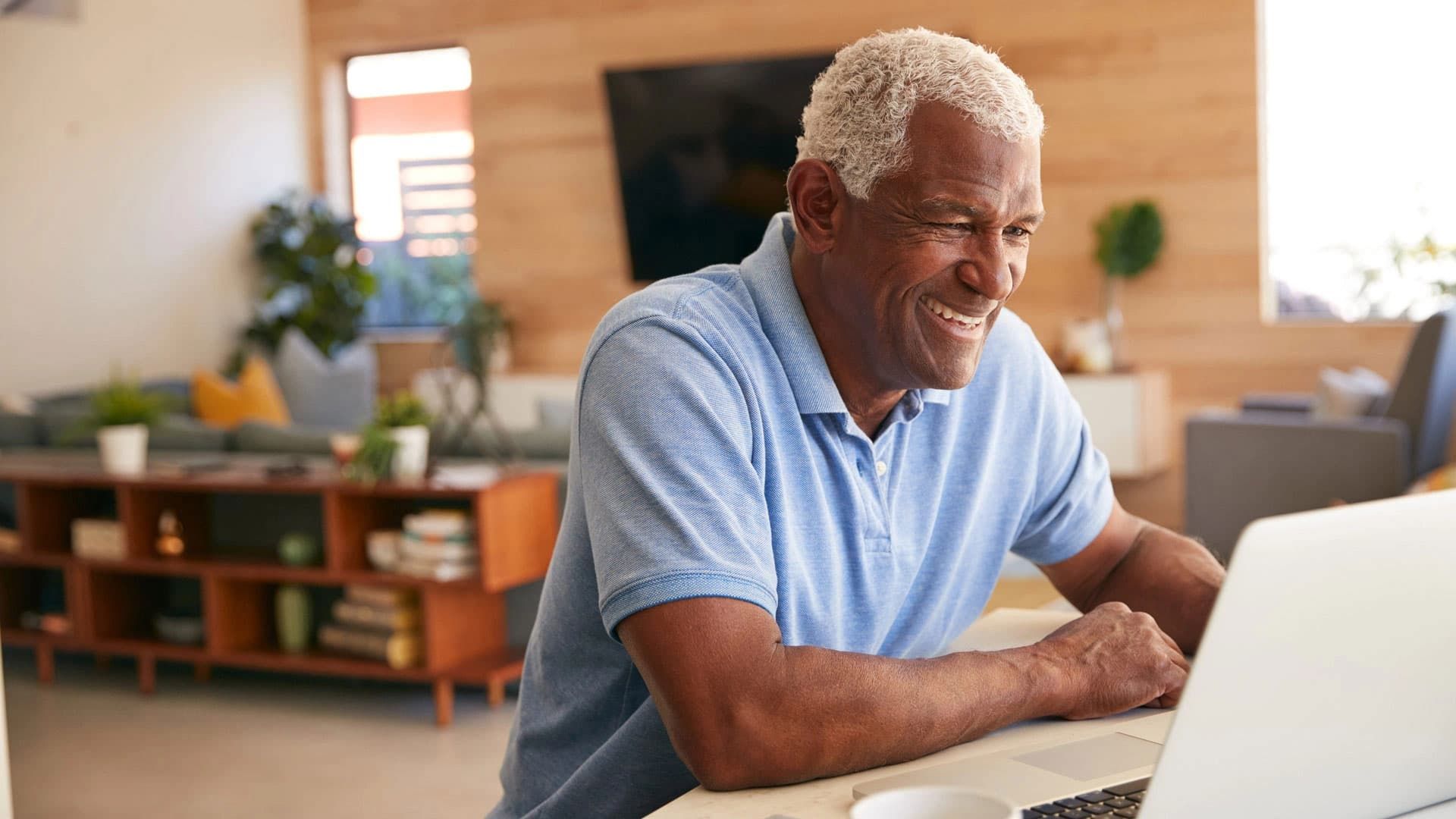 man smiling infront of laptop