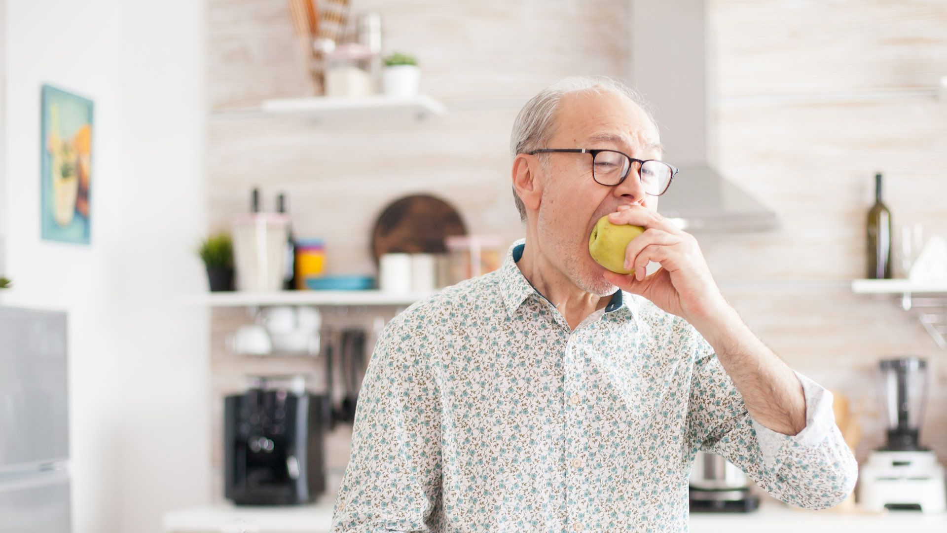elderly gentleman eating an apple