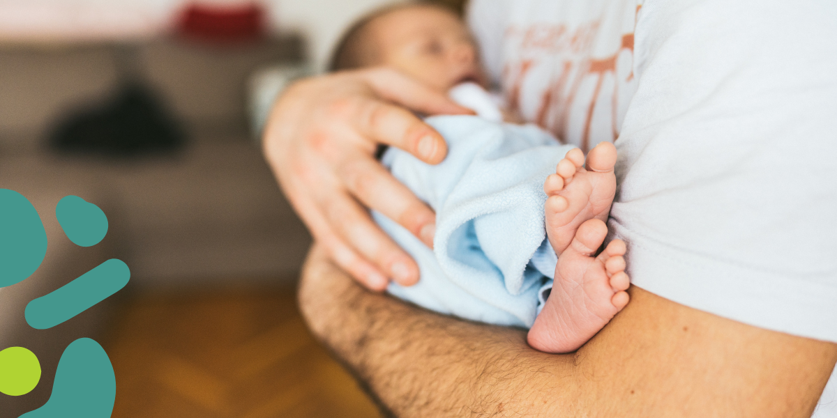newborn baby held by adoptive dad