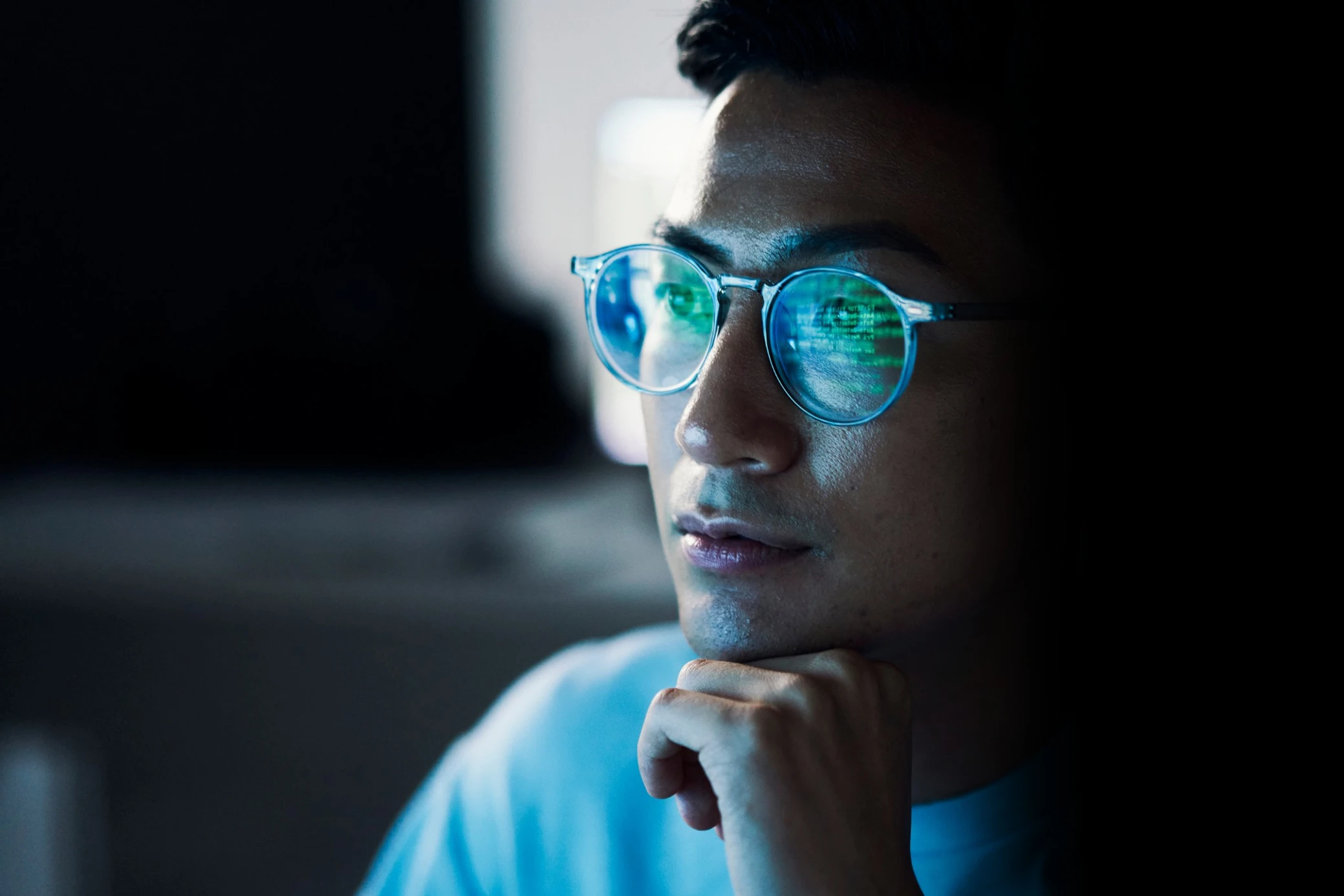 Trader in glasses studying market data on a screen