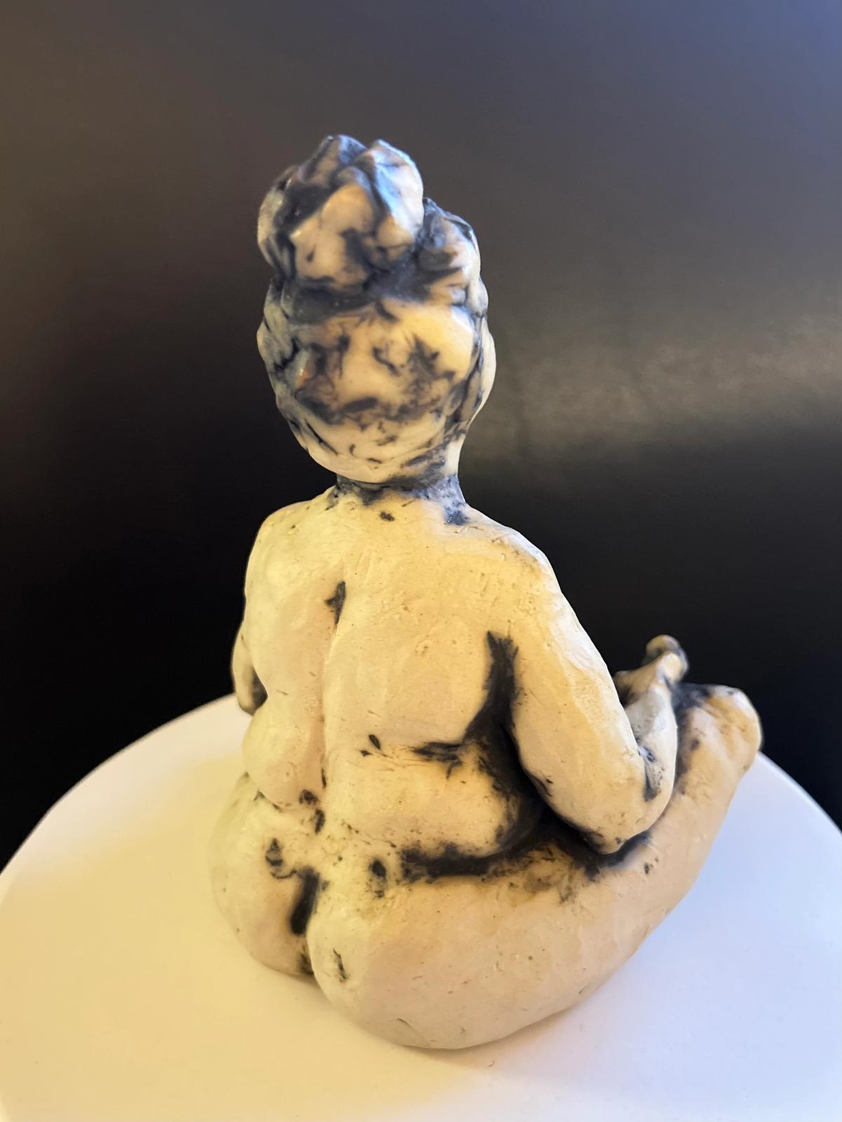 Keramikfigur af yogadame, der mediterer