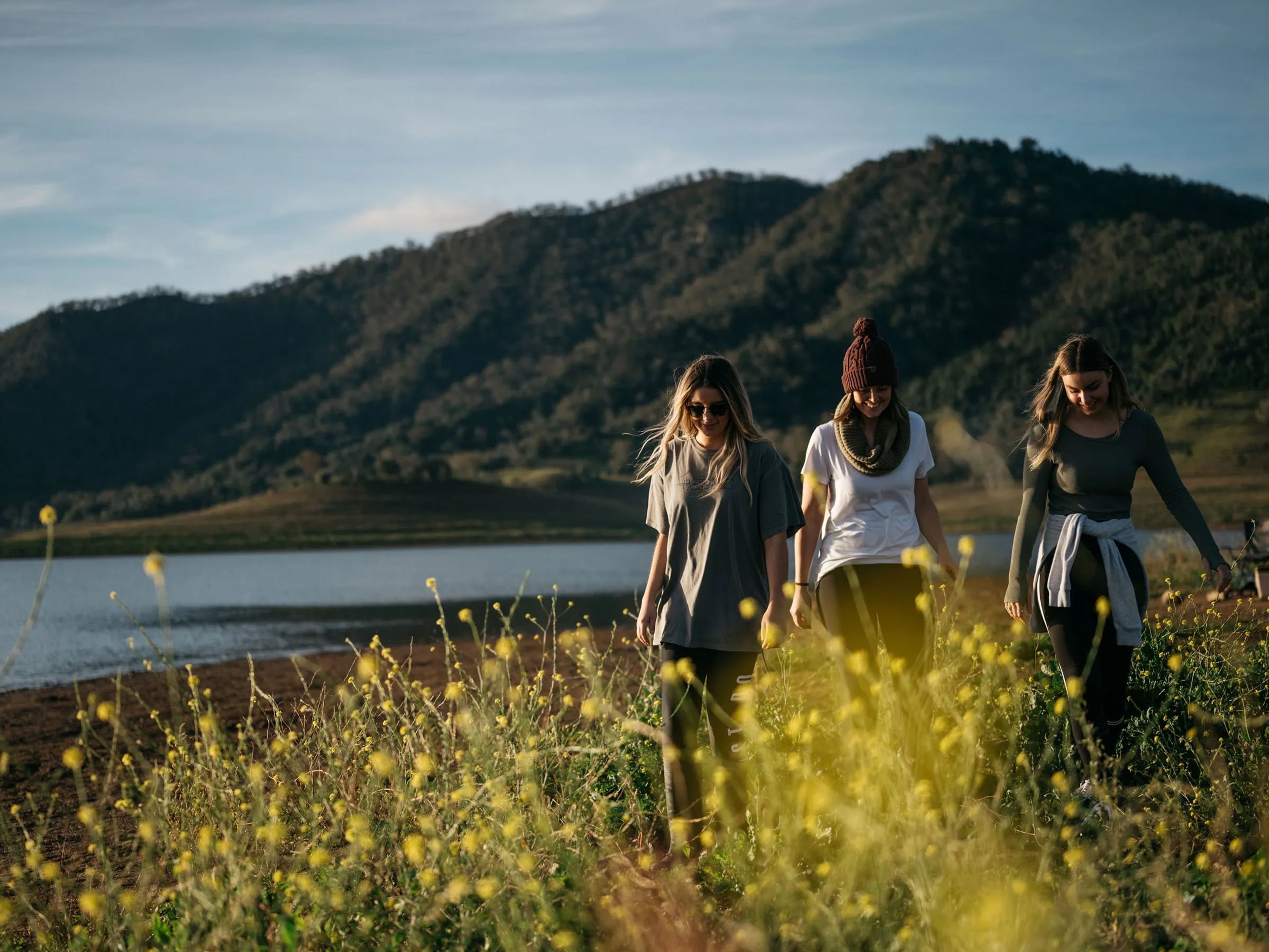 Three girls walking through wildflowers