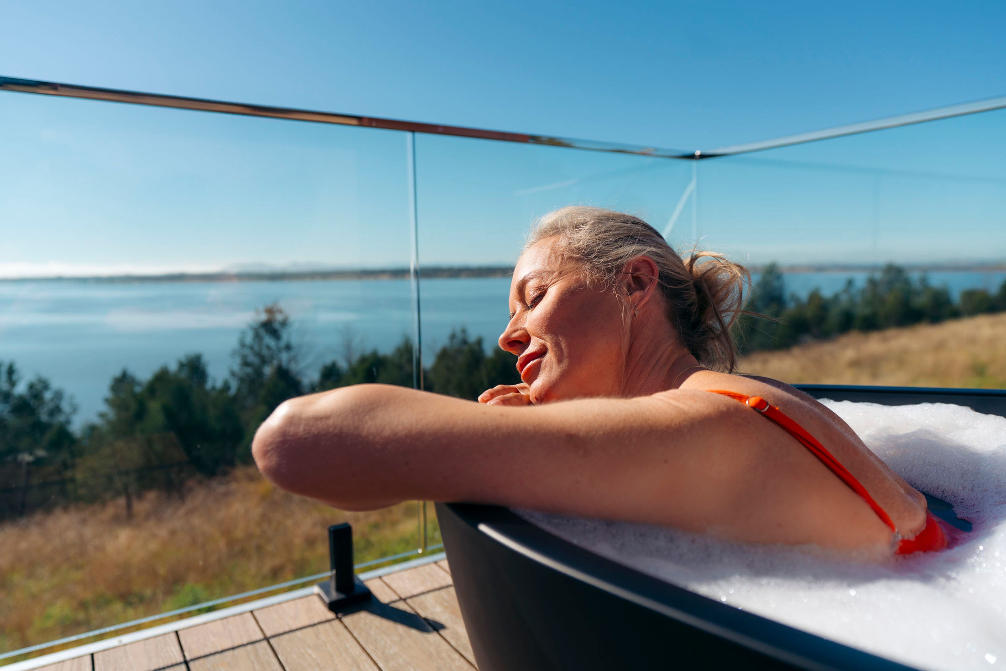 Wilderluxe Lake Keepit - woman in her bath on the deck of her star tent