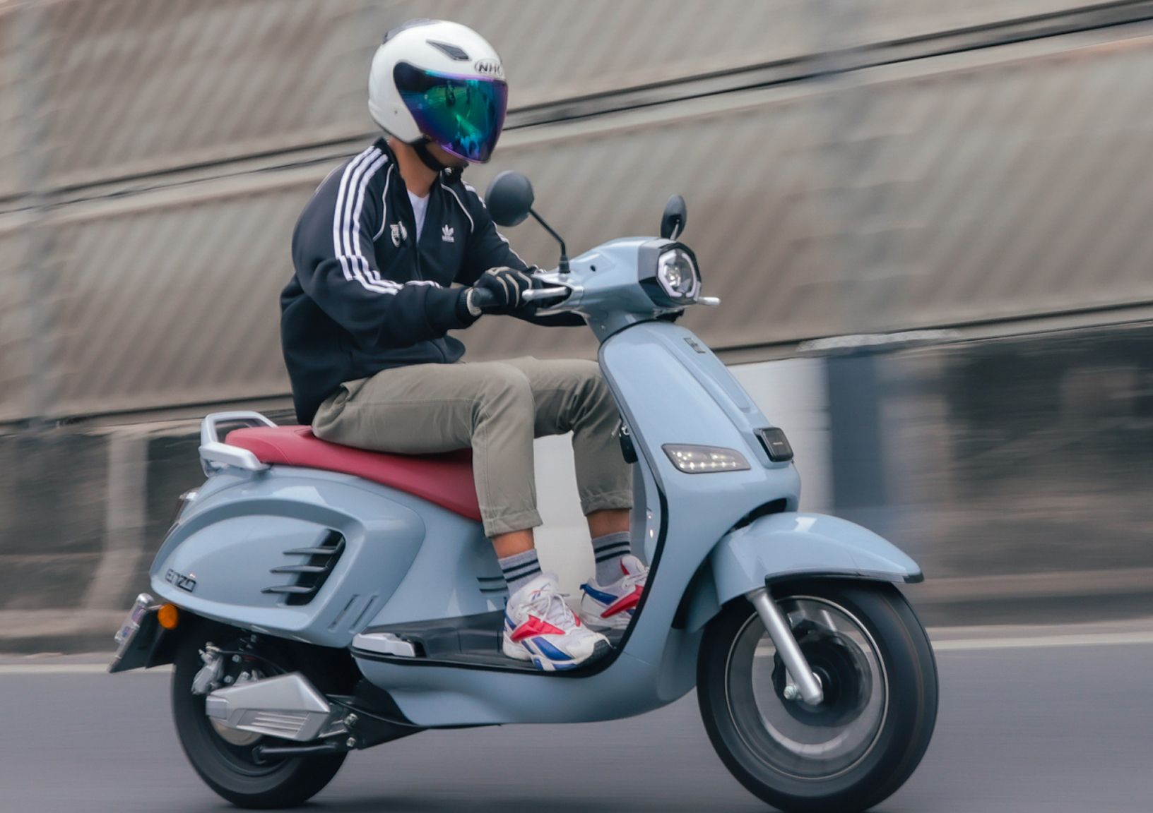 The driver driving EM E-Moto over the bridge