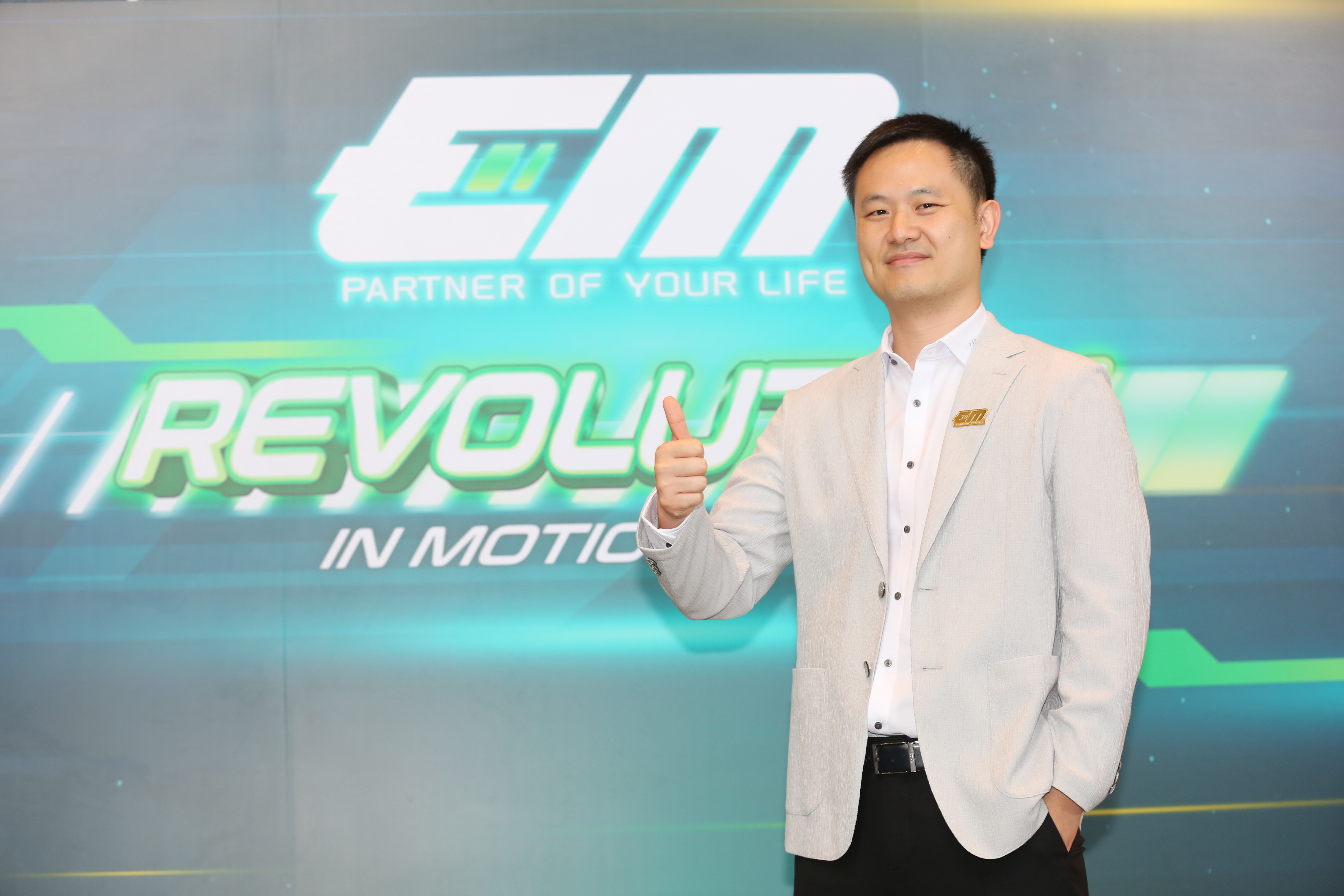 ภาพถ่ายคุณซัน ธานัท พรหมธรรมกุล ยืนถ่ายหน้า backdrop Revolution in Motion