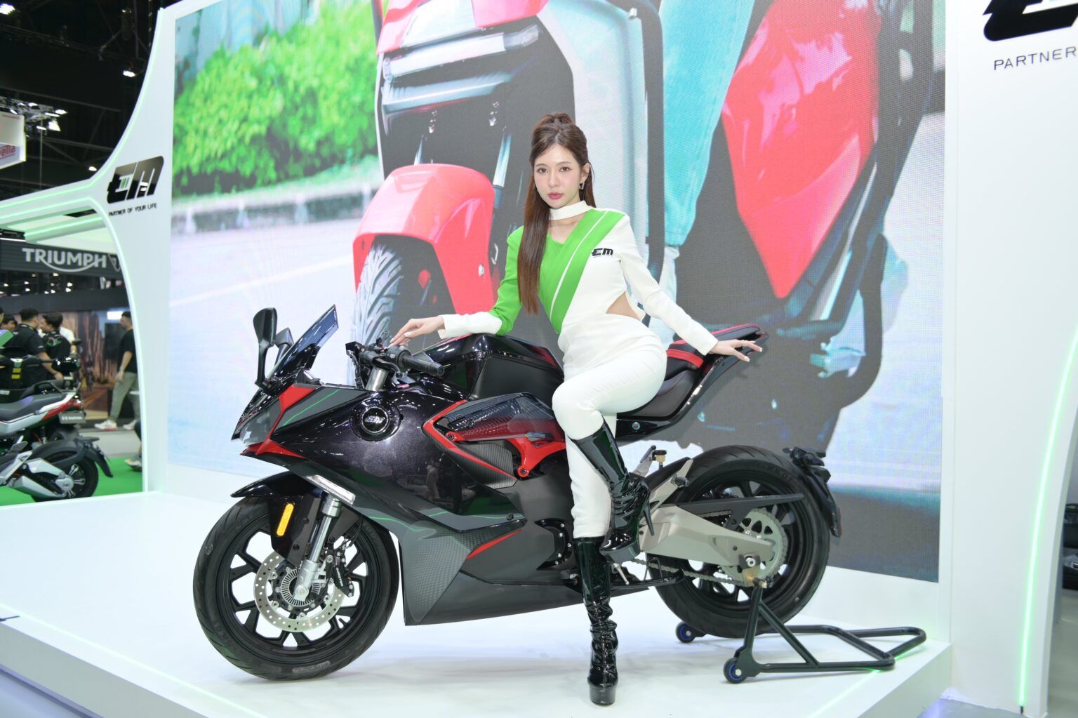 ภาพพนักงานแนะนำสินค้ากับมอเตอร์ไซค์ไฟฟ้า EM RX5