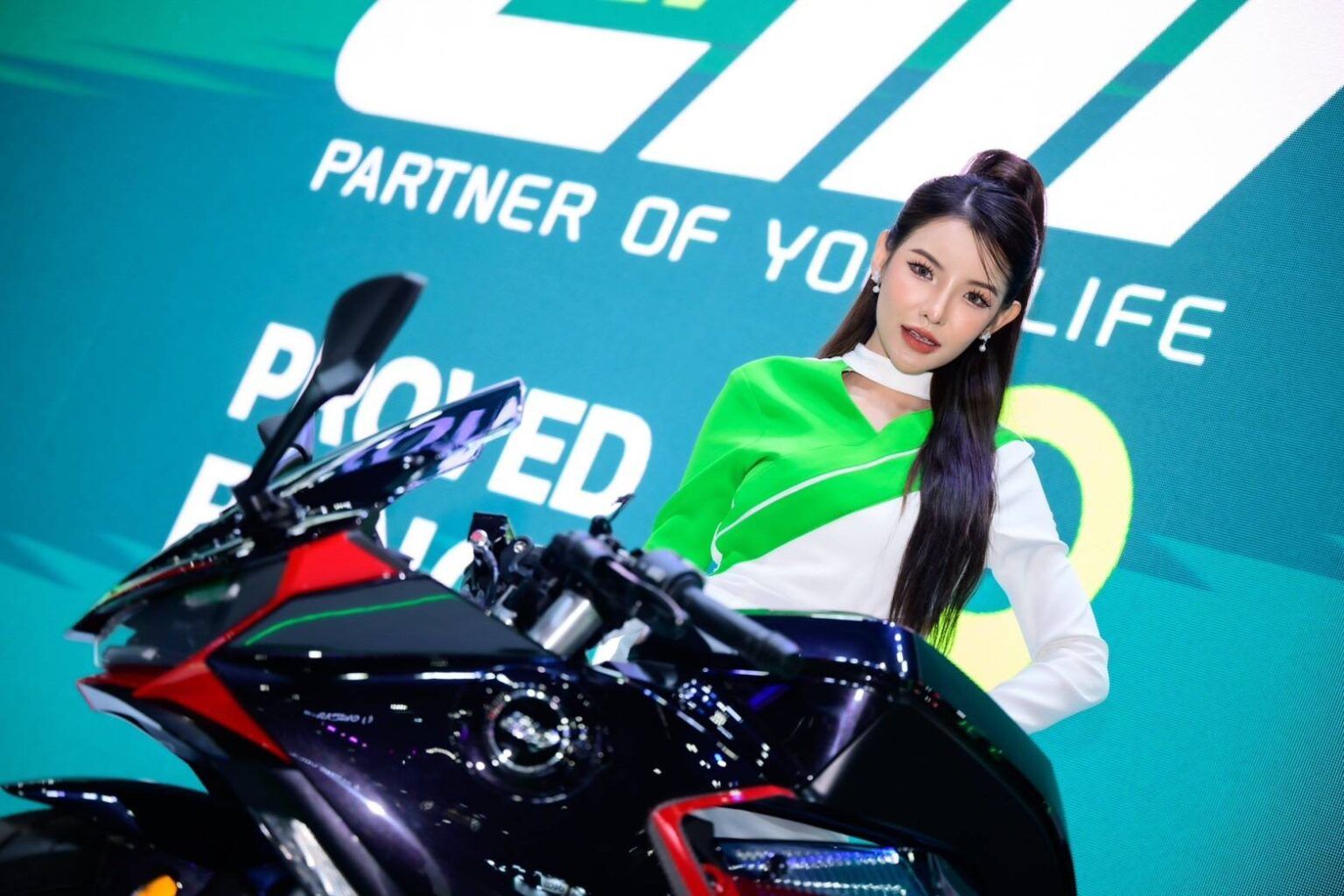 ภาพ Close Up พนักงานแนะนำสินค้ายืนหลัง EM RX5 ด้านหลังเป็น backdrop EM Motor