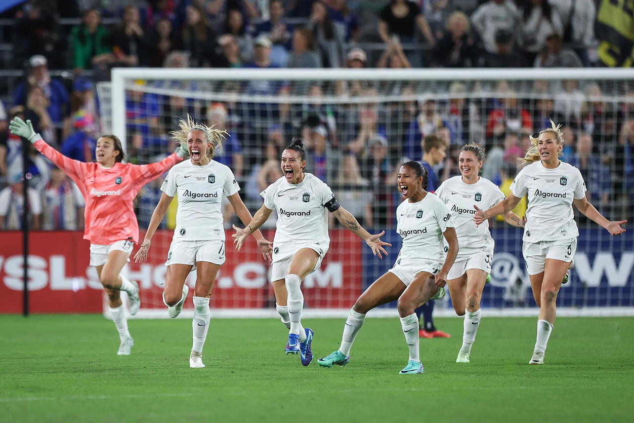 womens soccer team celebrating in front of the goal after a win