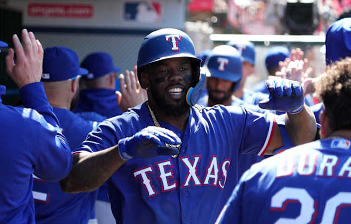 former Texas Ranger Adolis García in the dugout high-fiving team mates