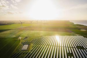 Wind turbines and solar panels farm in a field