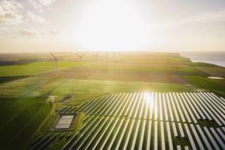 Wind turbines and solar panels farm in a field
