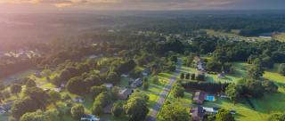 Aerial view a town community with houses and landscape during sunrise