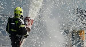 A firefighter spraying firefighting foam