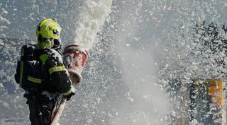 A firefighter spraying firefighting foam