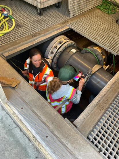 Two women working in a pipe hatch