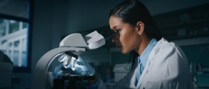 Woman working in healthcare looking through a microscope