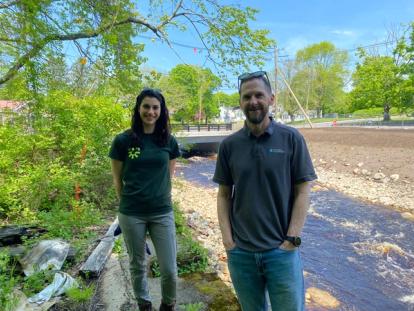 Taylor DelVecchio and Andie Green standing in front of the Town River and newly constructed bridge