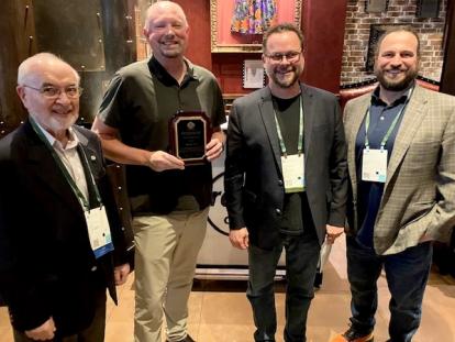 SLR Geologist Matthew Lesh holding award plaque with other attendees