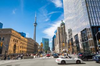 Pedestrians and cars at busy downtown Toronto intersection