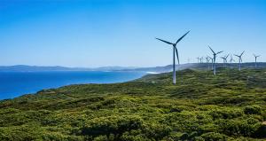 A wind farm on a hillside overlooking the ocean