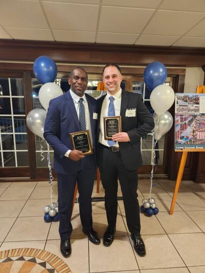 Kwesi Brown and Paul DeStefano standing together, holding the 2025 Merit Award plaques from ACEC-CT.