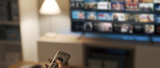 Young woman watching video on demand on her TV