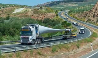 A haulage truck transporting a wind turbine blade along a road