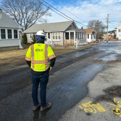 SLR engineer inspecting road with flooding