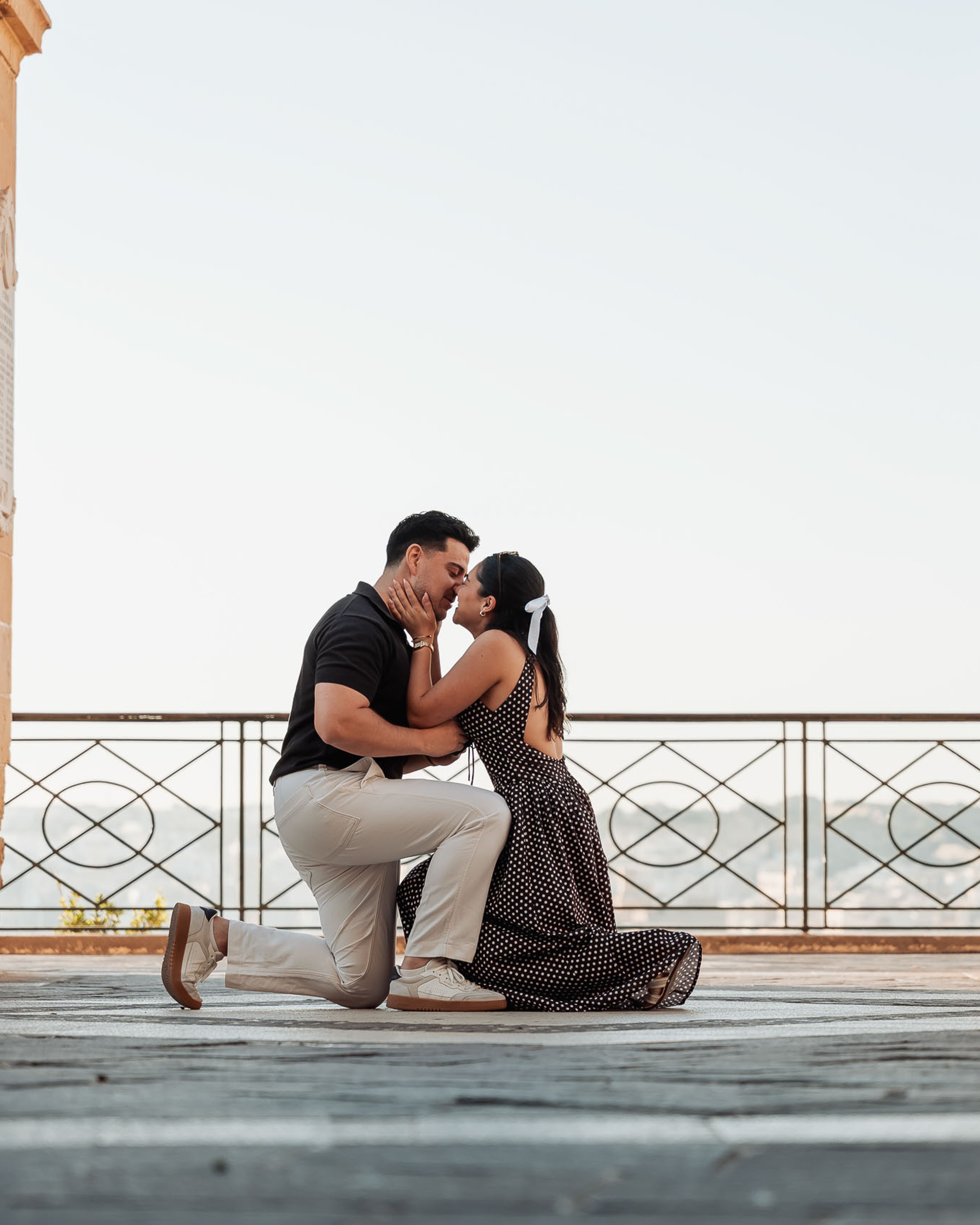 Surprise proposal at Upper Barrakka Gardens in Valletta, Malta, as he gets down on one knee.