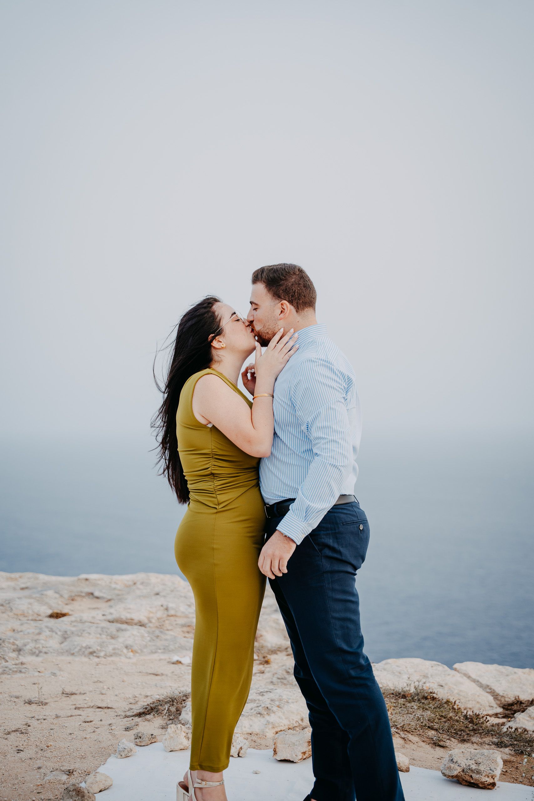 Newly engaged couple kissing after a surprise proposal at Dingli Cliffs, Malta