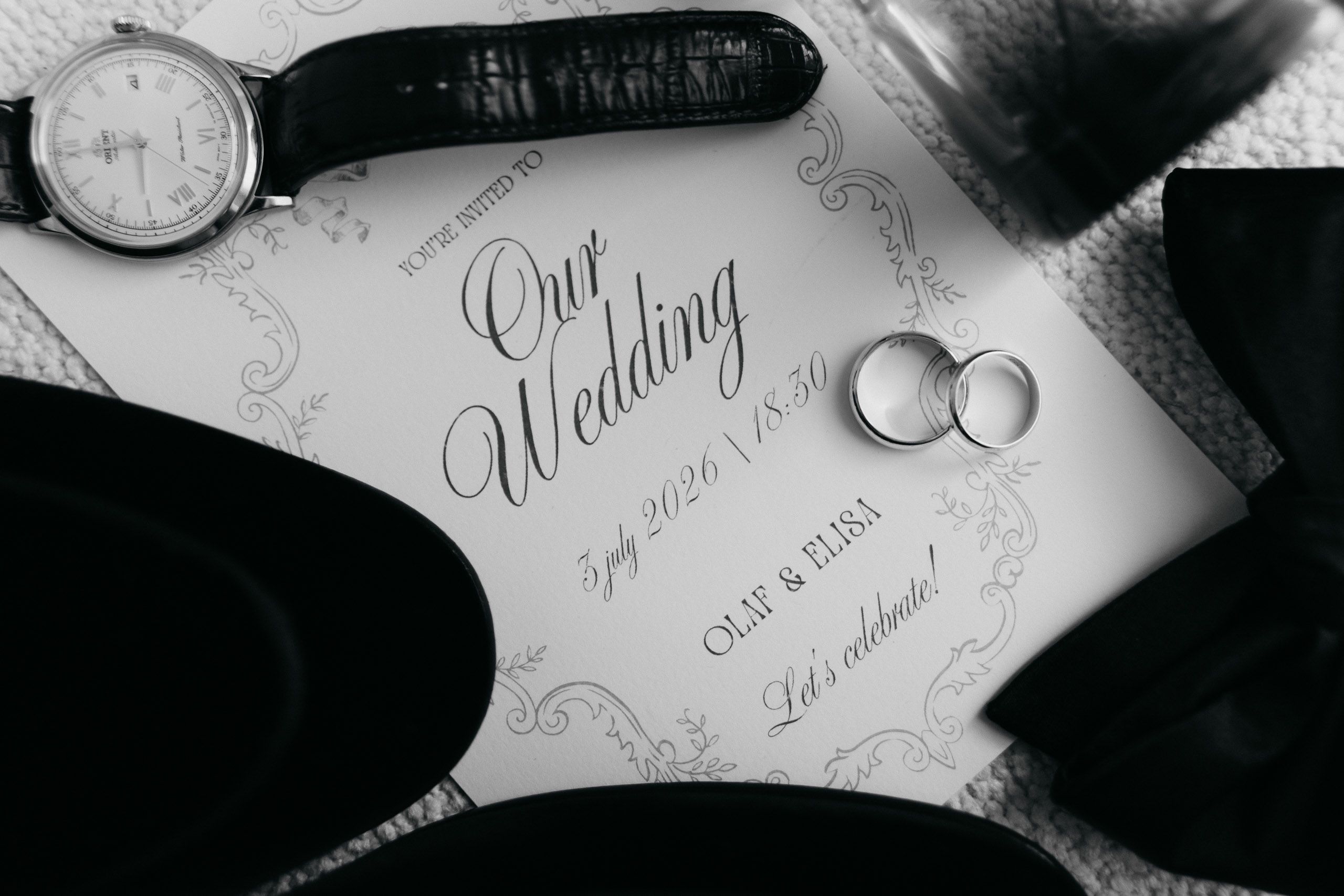 Wedding rings and groom’s watch arranged on Olaf and Elisa’s wedding invitation in Den Helder, Netherlands.