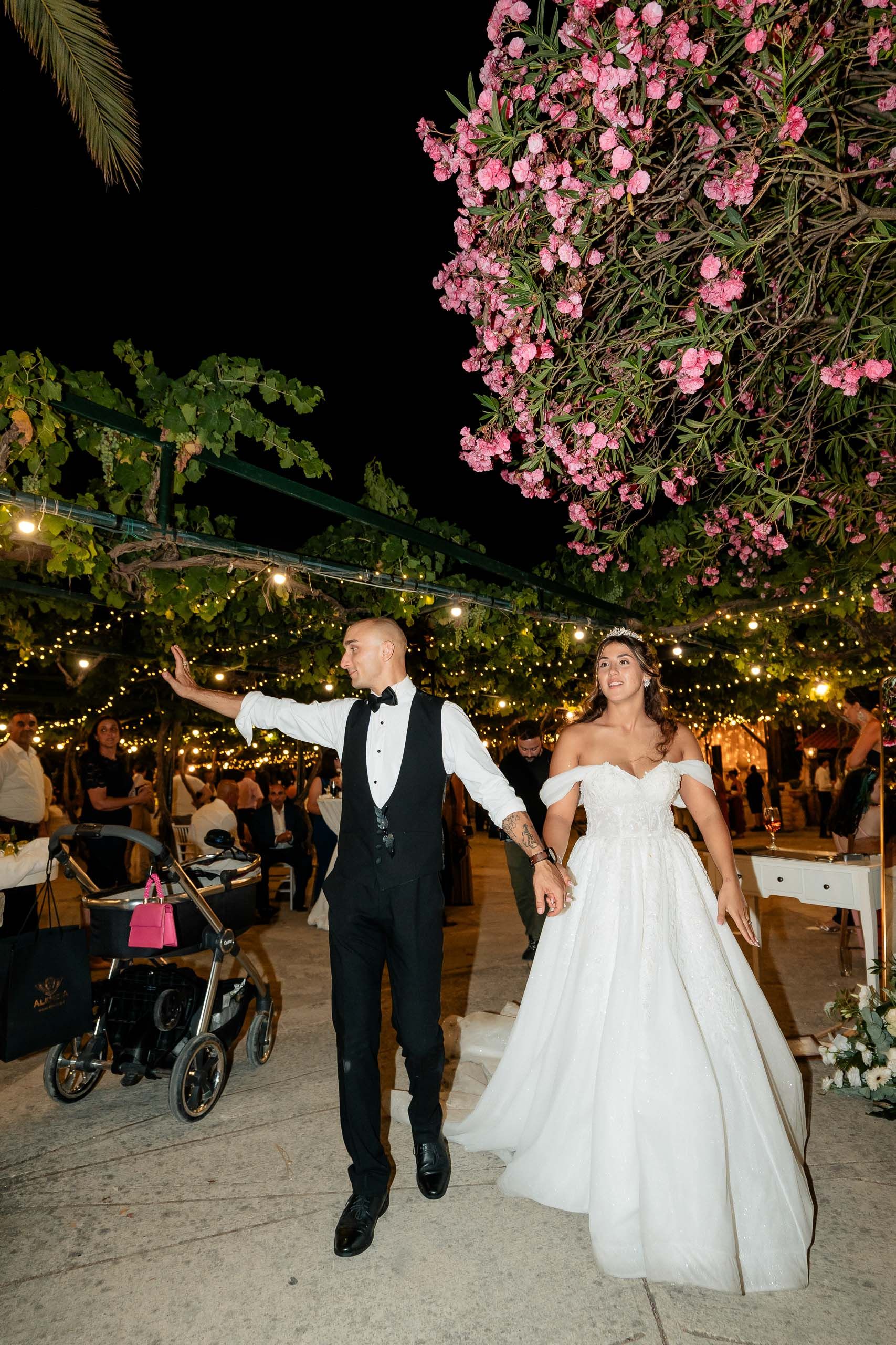 ride and groom walking hand in hand during their wedding going away at Ir-Razzett L-Abjad in Malta.