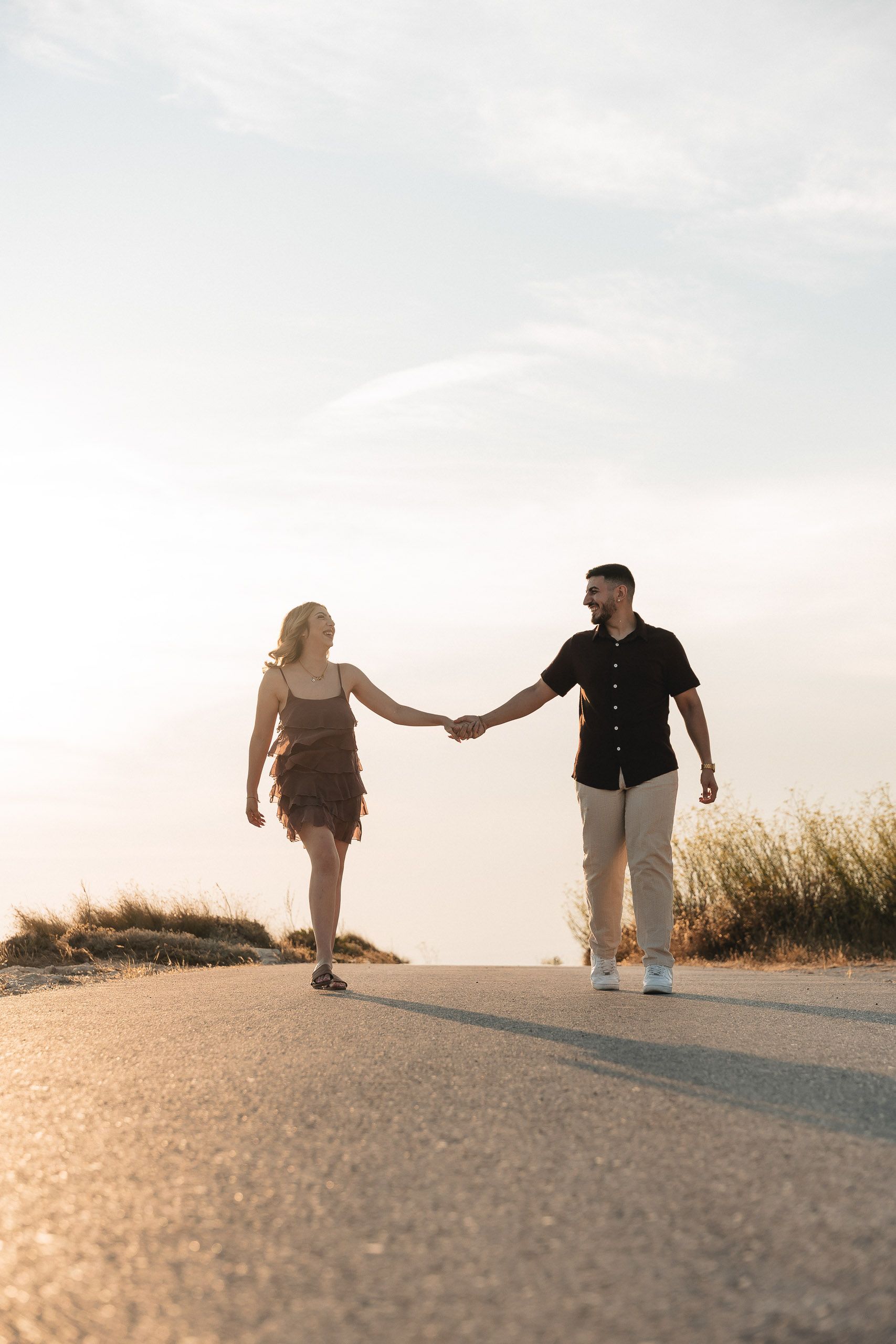 Couple walking hand in hand during a proposal photoshoot at Dingli Cliffs, Malta