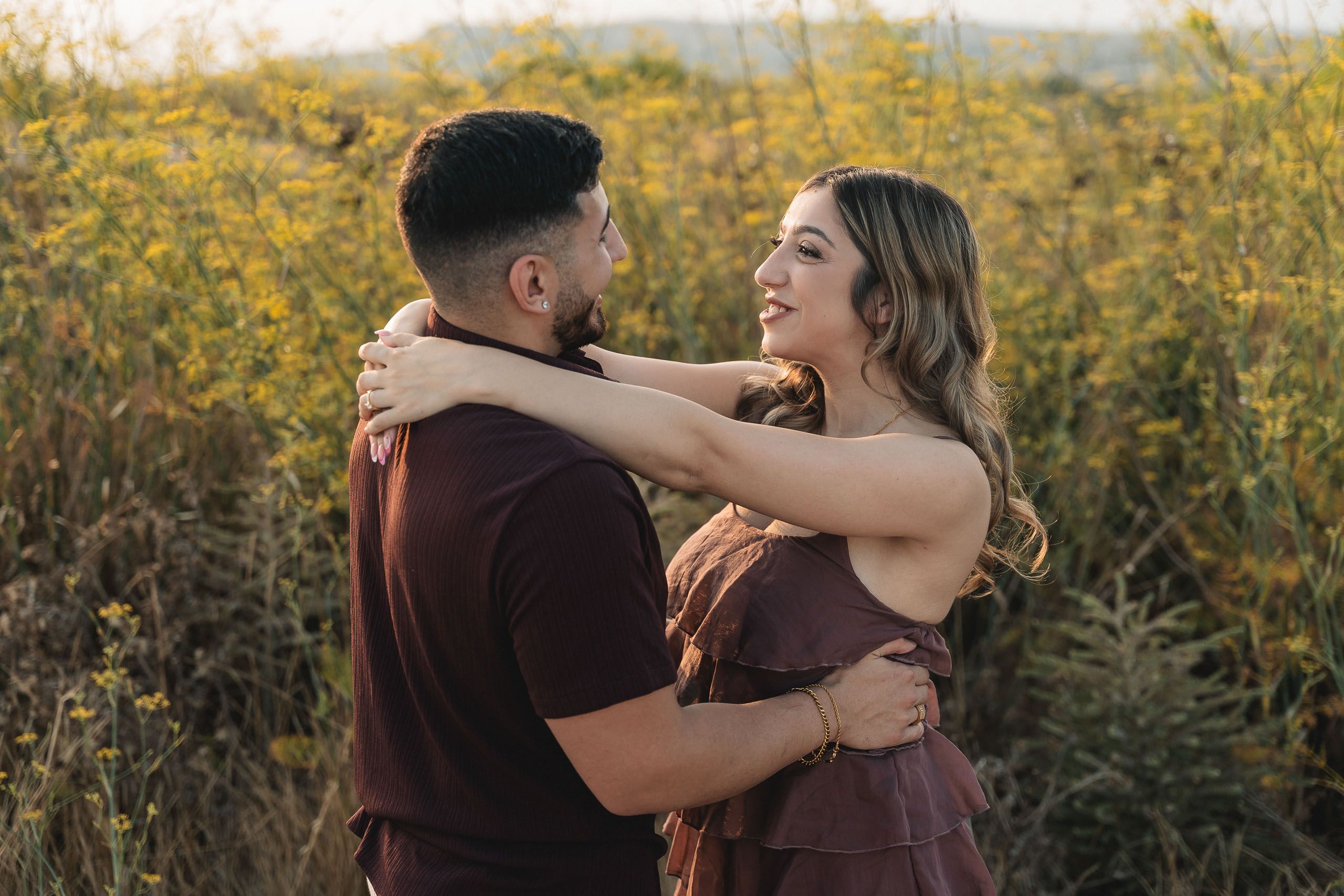 Newly engaged couple embracing during a sunset proposal session at Dingli Cliffs