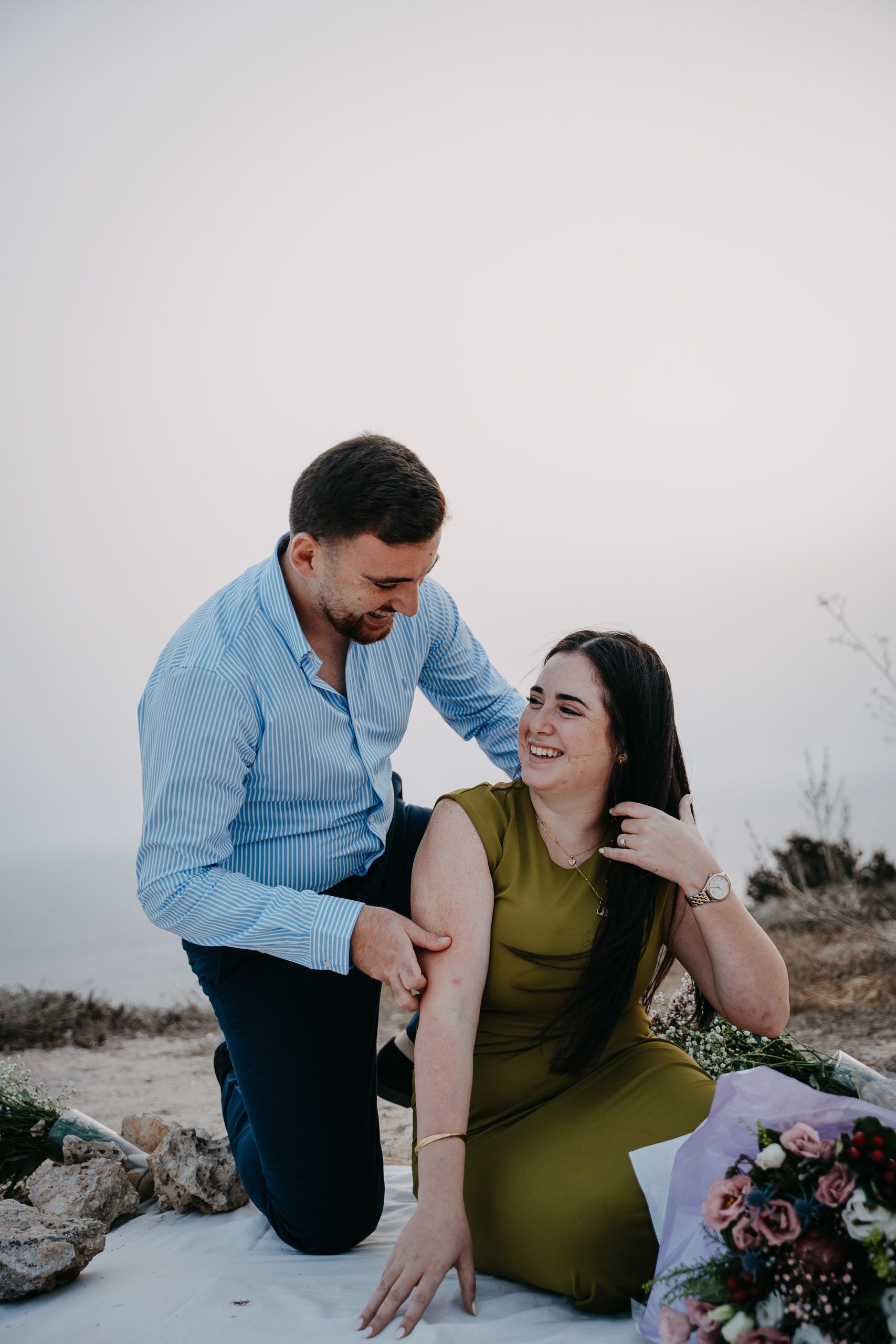 Newly engaged couple laughing during a proposal photoshoot at Dingli Cliffs, Malta