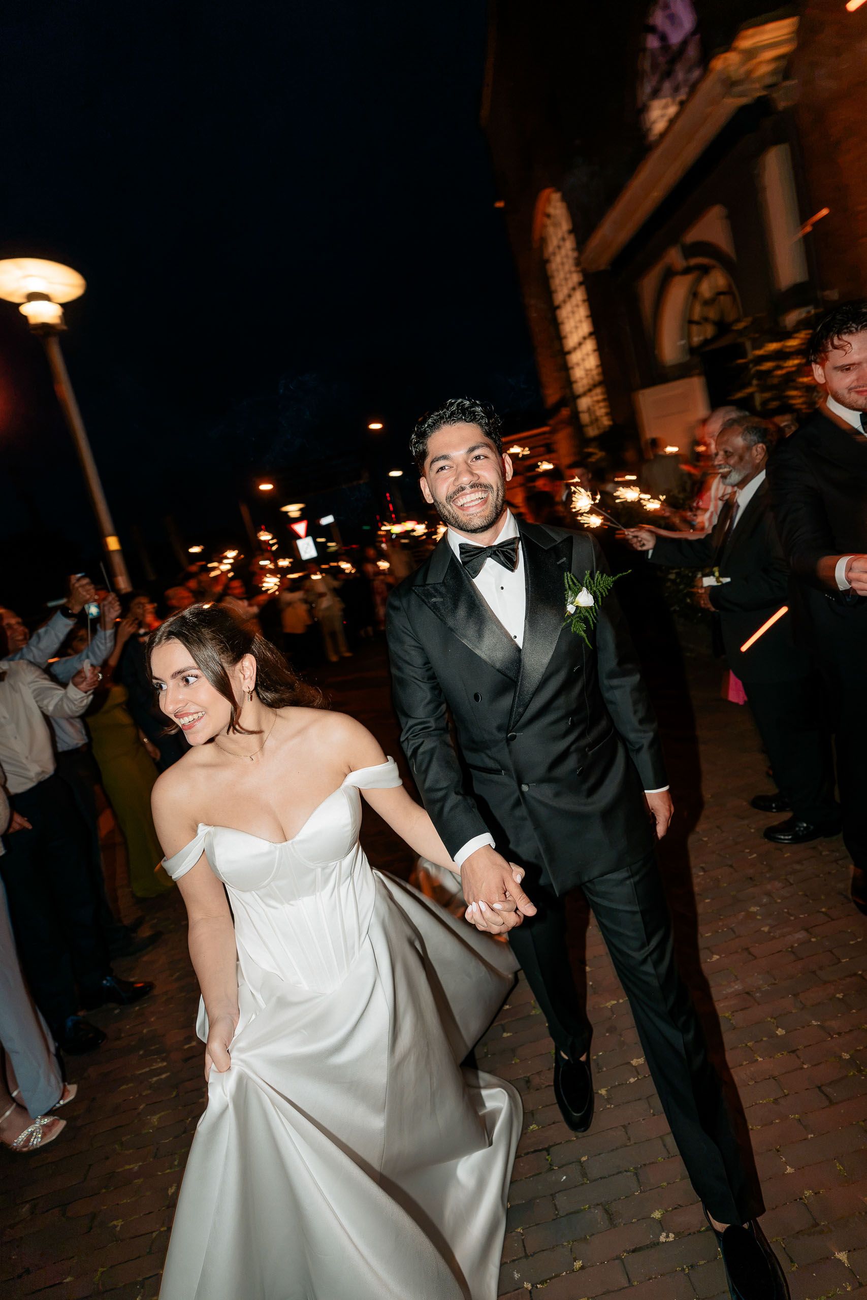 Bride and groom walking through a sparkler exit after their wedding celebration in Den Helder, Netherlands.