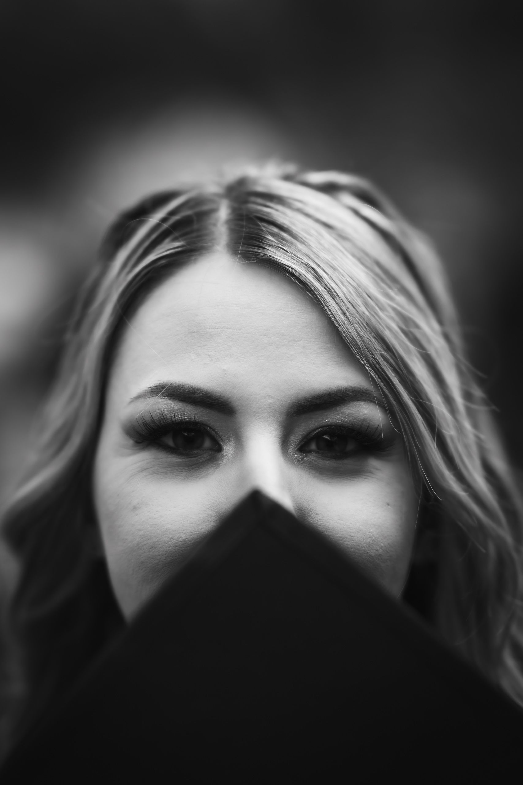 Black-and-white close-up of a graduate looking over her graduation cap at San Anton Gardens in Malta.