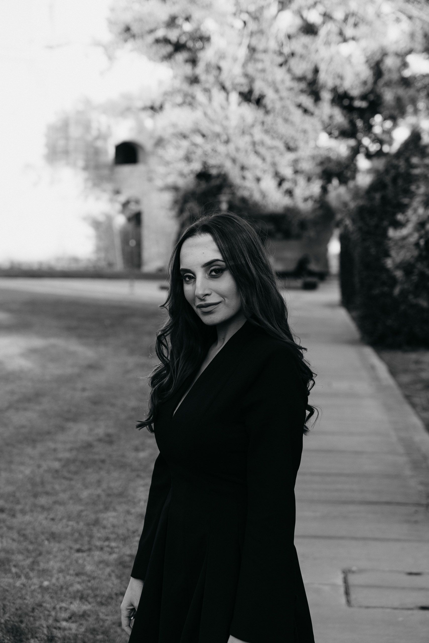 Black-and-white portrait of a graduate looking back at the camera during a photoshoot in Mdina, Malta.