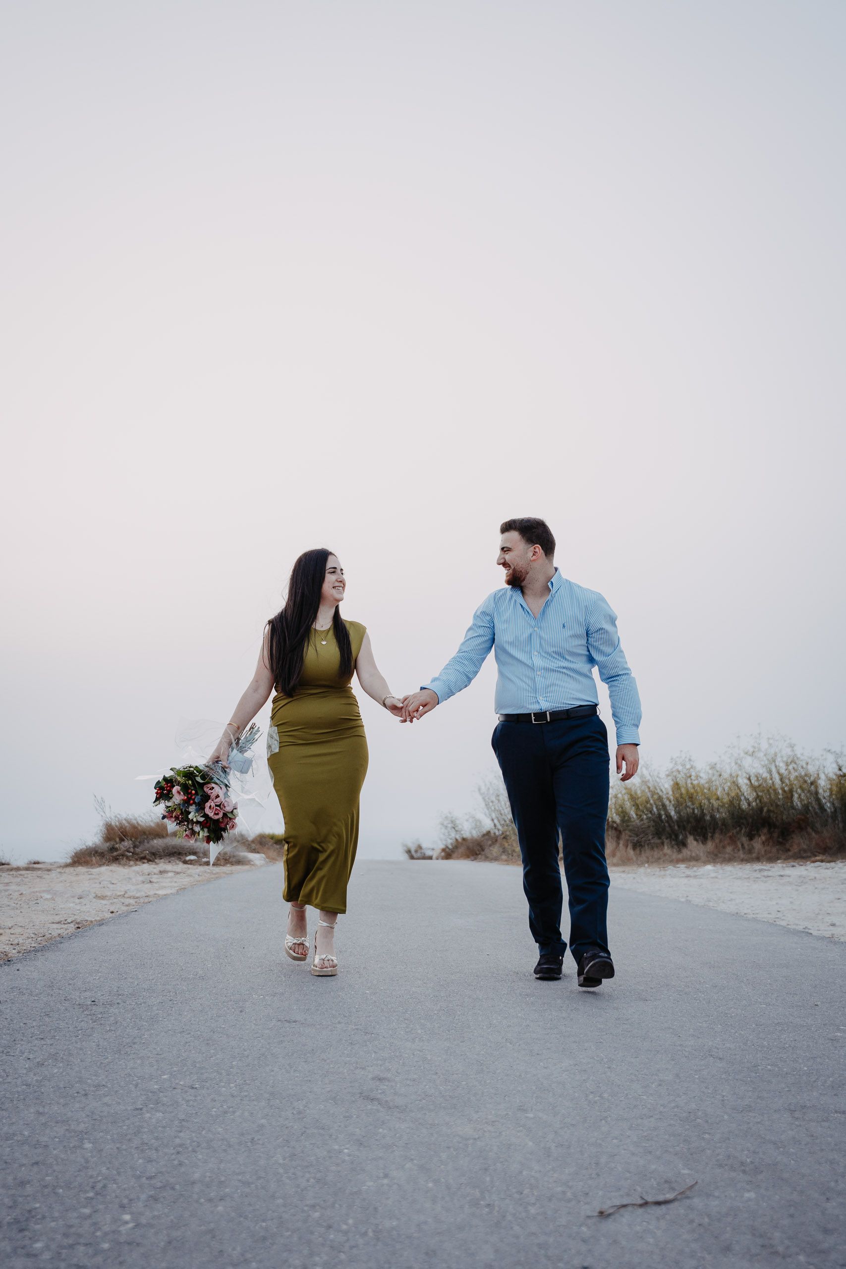 Newly engaged couple walking hand in hand after a proposal at Dingli Cliffs, Malta