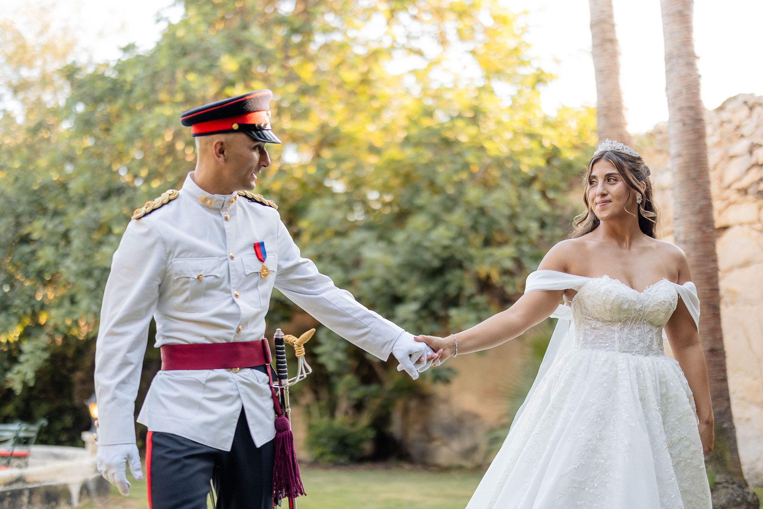 Bride and groom holding hands during their wedding portraits in the gardens at Ir-Razzett L-Abjad in Malta.