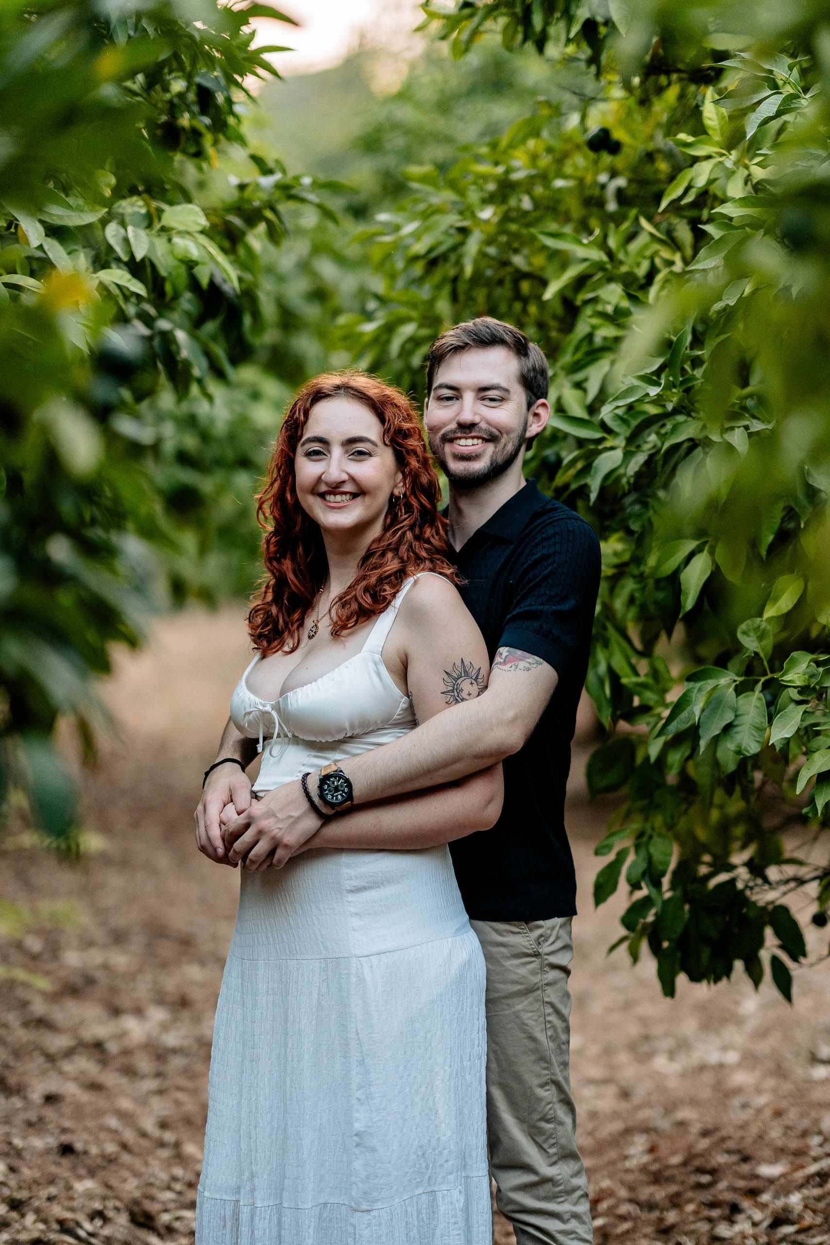 Jay and Cristina embracing among the greenery during their pre-wedding shoot at Buskett Woodlands in Rabat, Malta.
