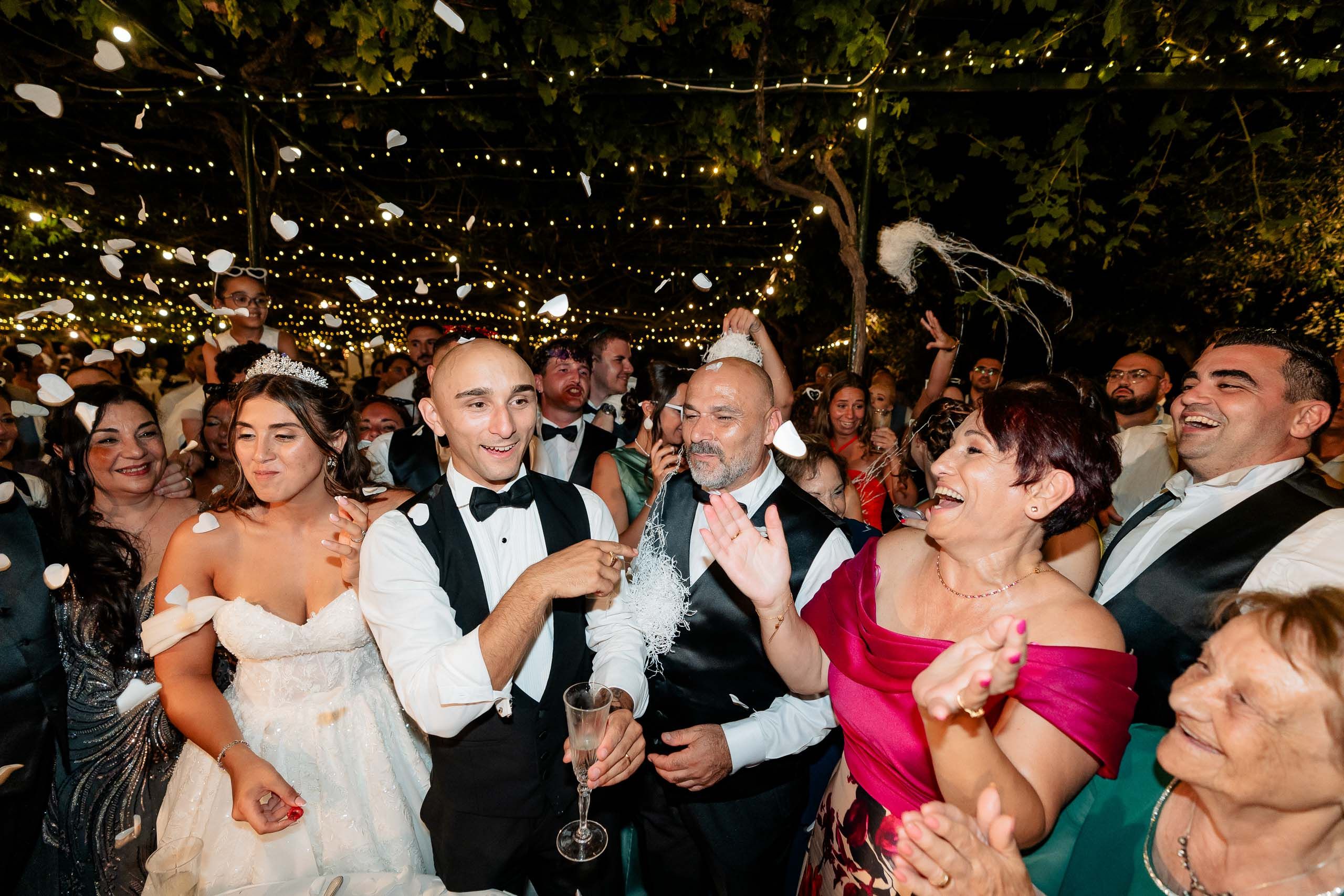 Bride and groom celebrating with family and friends during their wedding reception at Ir-Razzett L-Abjad in Malta.