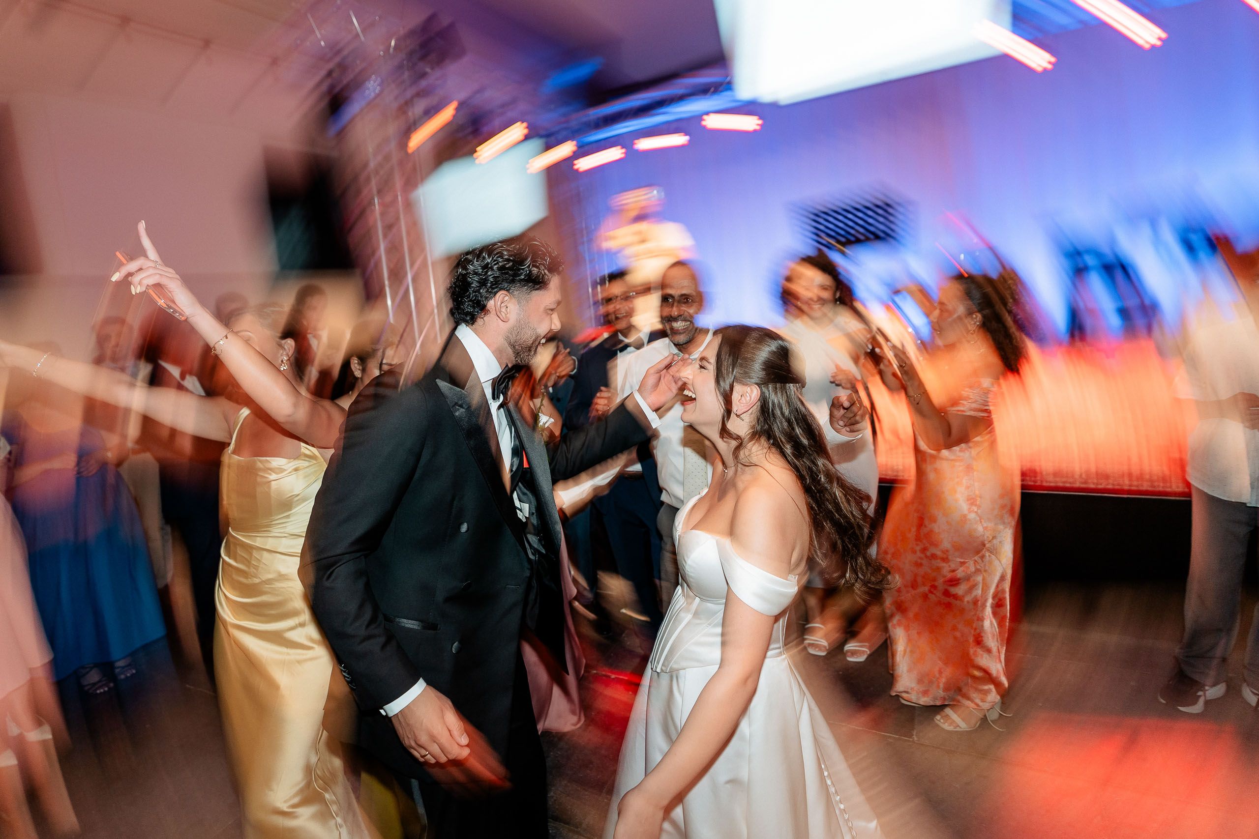 Bride and groom dancing with guests during their wedding reception in Den Helder, Netherlands.