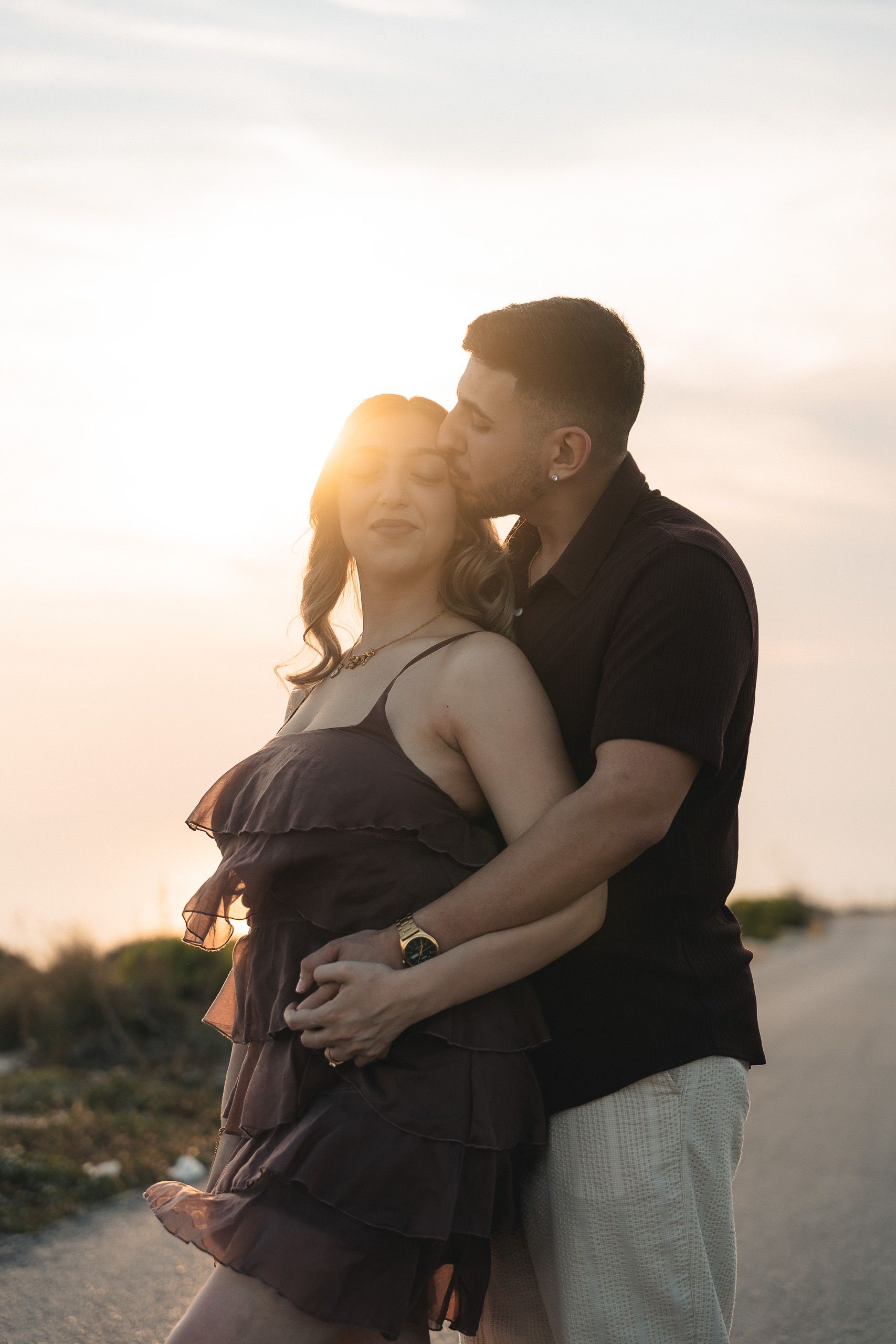 Engaged couple sharing an intimate moment at sunset at Dingli Cliffs, Malta