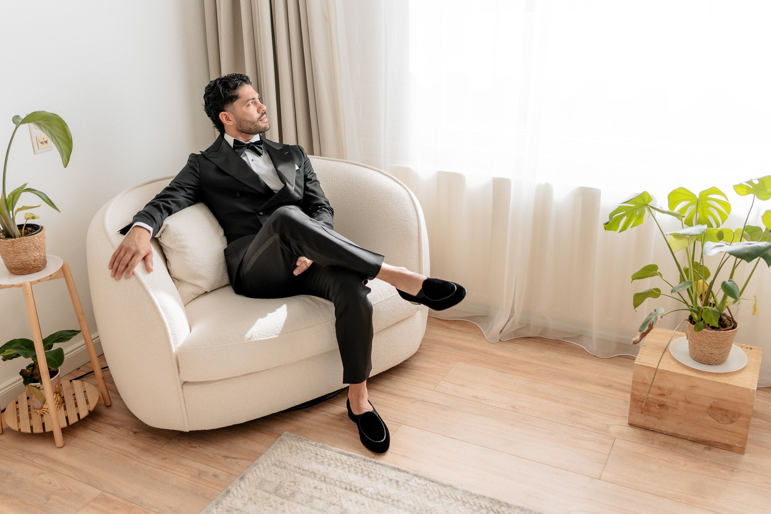 Groom seated in a black tuxedo during his wedding preparations in Den Helder, Netherlands.