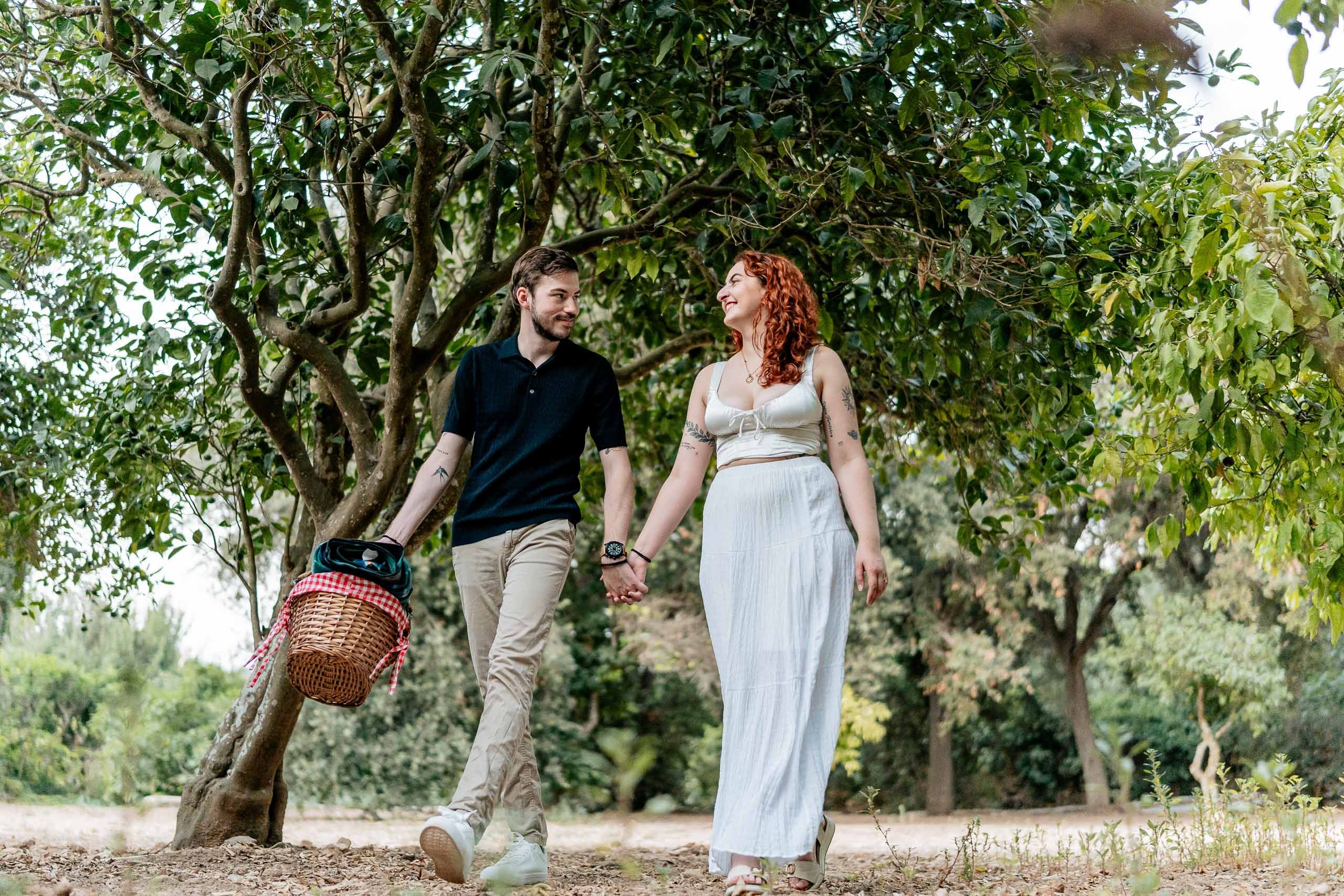 Jay and Cristina walking hand in hand through Buskett Woodlands during their pre-wedding shoot in Rabat, Malta.