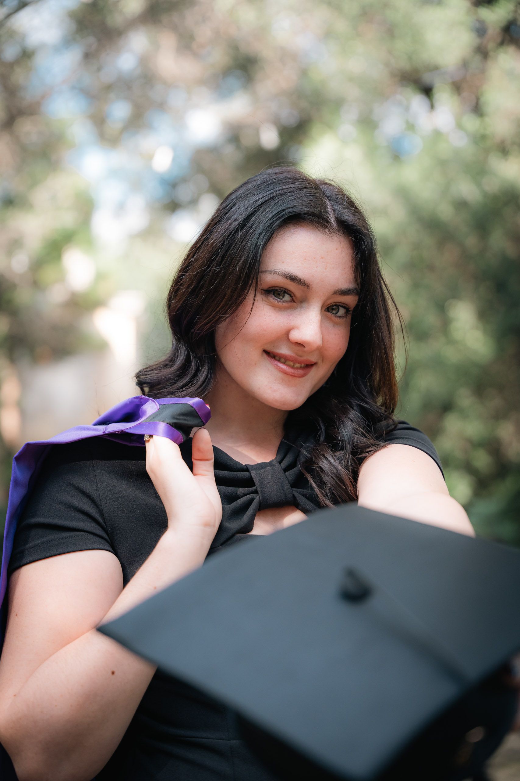 Close-up portrait of a graduate holding her cap at Romeo Romano Gardens in Malta.