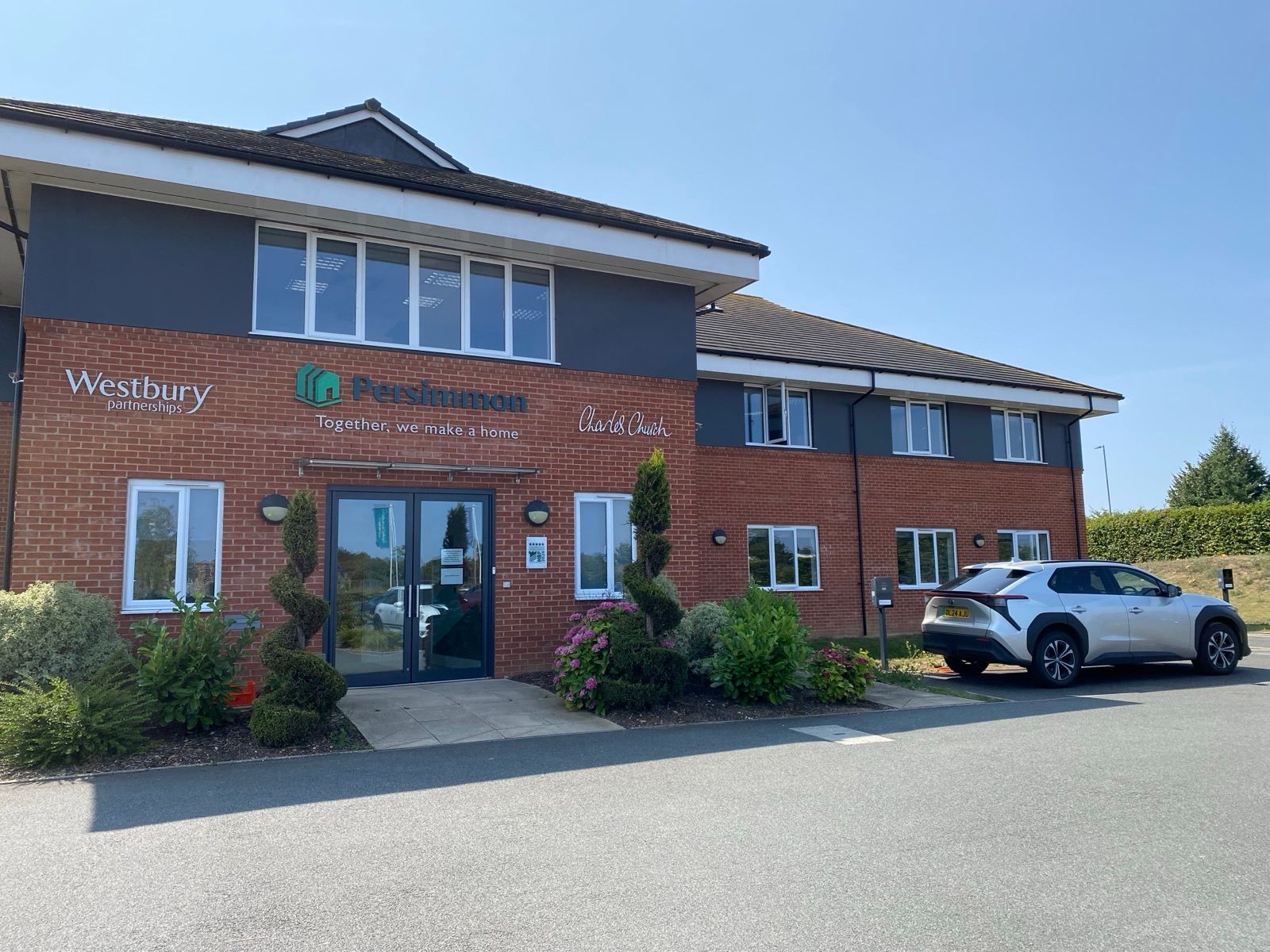 The Fernham Homes head office with a car parked beside a Brim charger